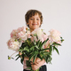 Cheerful happy child with Peonys bouquet. Smiling little boy on white background. - PhotoDune Item for Sale