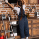 young repairwoman in overall examining stove hood at kitchen - PhotoDune Item for Sale