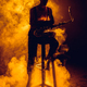 silhouette of young musician sitting on stool and holding saxophone in smoke - PhotoDune Item for Sale