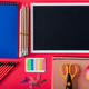 top view of blank blackboard, apple and arranged variety stationery on red background - PhotoDune Item for Sale