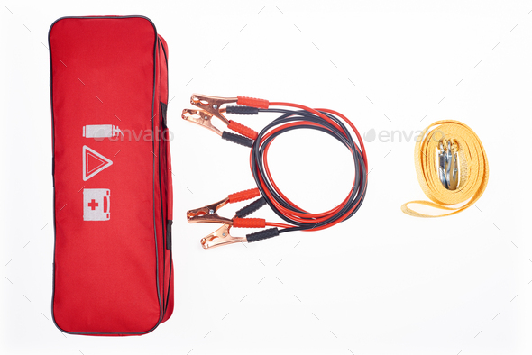 flat lay with arrangement of automotive handbag, car tow rope and jump start cables isolated on