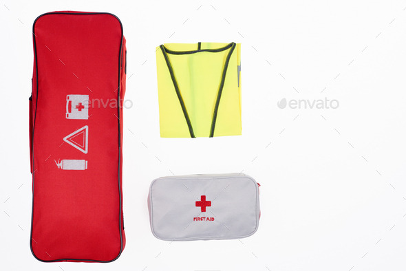 flat lay with automotive handbag, first aid kit and reflective vest isolated on white