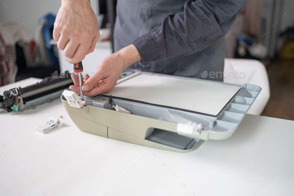 Specialist repairs the printer cartridge, fuser unit close-up. printer repair technician.