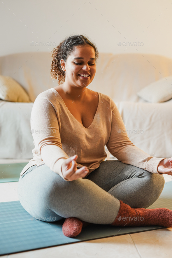 Young curvy african girl doing yoga exercise at home Stock Photo