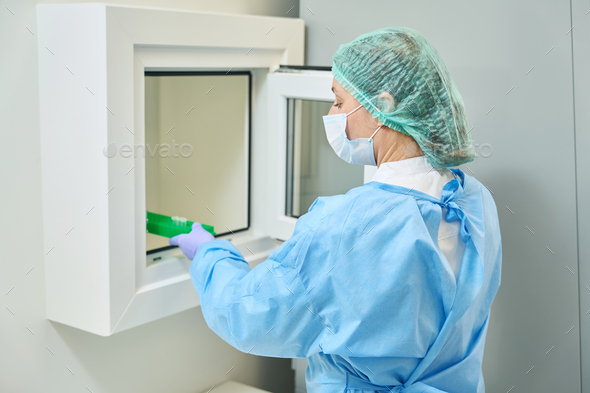 Virologist laboratory assistant transfers images of viruses from sterile room