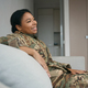 Happy military woman is resting in a bright living room - PhotoDune Item for Sale