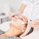 Beautician applying cosmetic cream mask on woman face for rejuvenation, procedure in beauty salon - PhotoDune Item for Sale