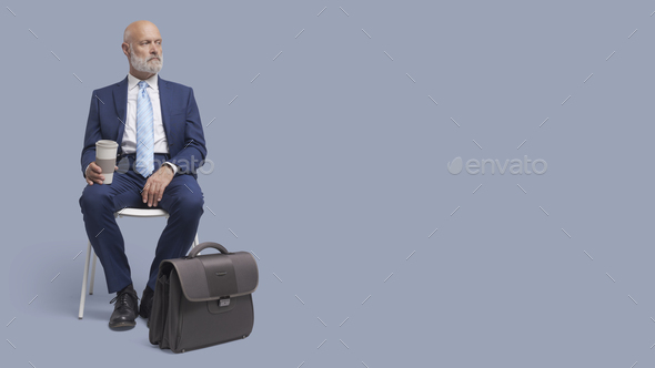 Businessman sitting on a chair and waiting - Stock Photo - Images