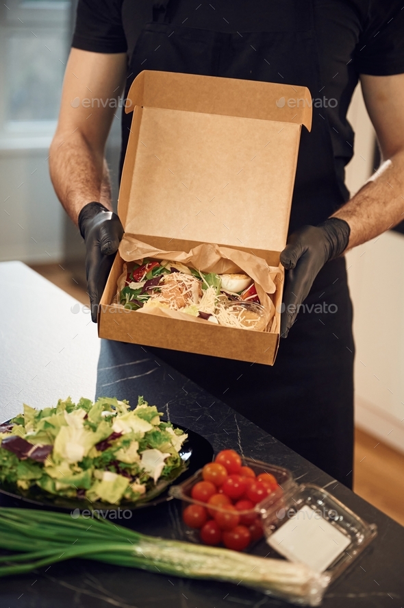 Holding And Showing Burgers And Vegetables. Man Is Packing Food Into 