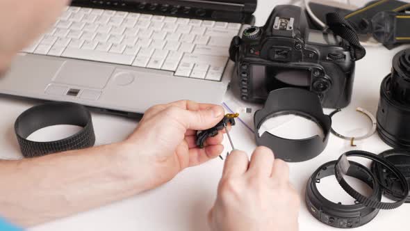 Man Repairs Camera Lens Autofocus Motor Tools