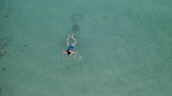 Top view of young woman swimming in the sea