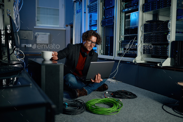 IT technician using laptop while working in data center