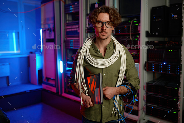 Portrait of signalman with many wires on shoulders and laptop in hand - Stock Photo - Images