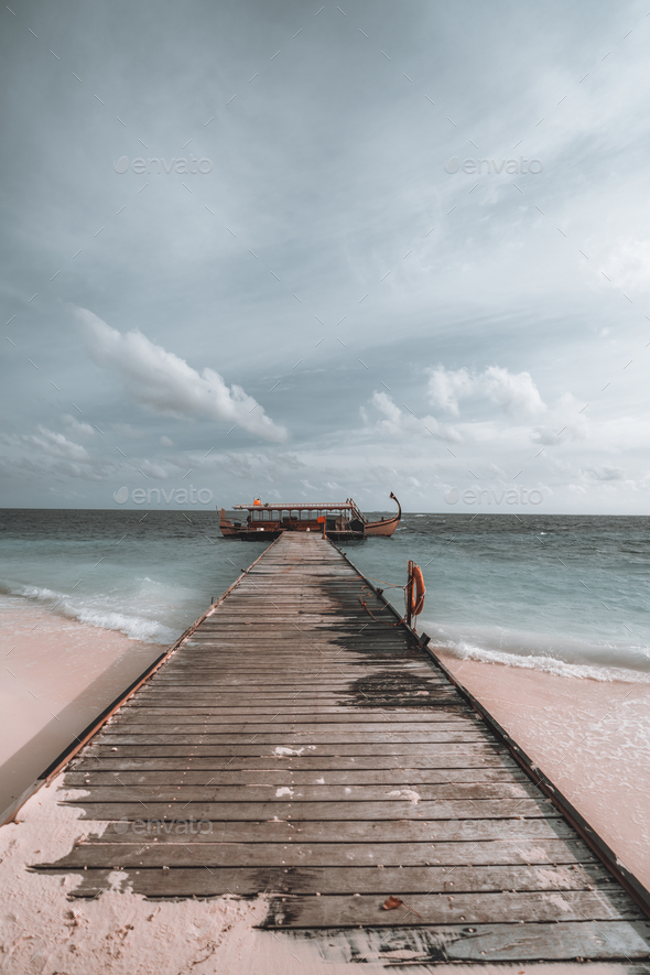 Vertical shot of a long wooden pier - Stock Photo - Images