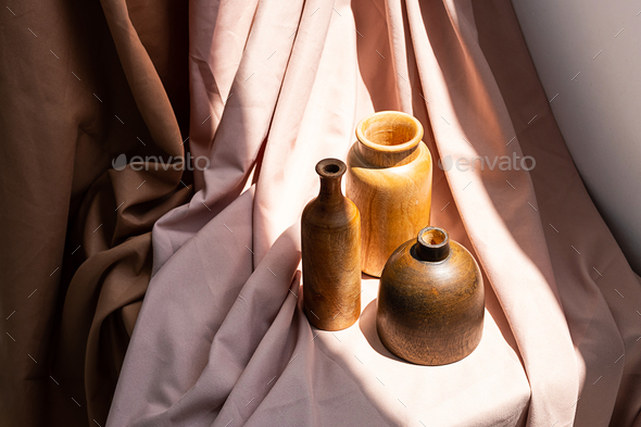 Wooden vases on textile background. Aesthetic vintage home decor collection.
