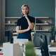 Serious businesswoman looking at camera while standing near her working place in office - PhotoDune Item for Sale