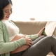 asian pregnant woman hands fondle on belly and holding green chroma key screen on tablet  - PhotoDune Item for Sale