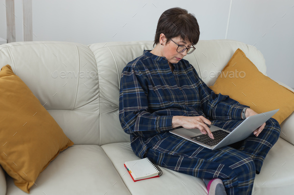 Businesswoman or blogger working on laptop computer sitting at home and managing her business via - Stock Photo - Images