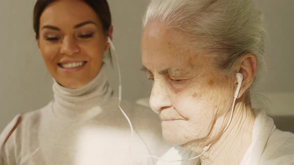 Senior and Young Women Watching Video on Gadget