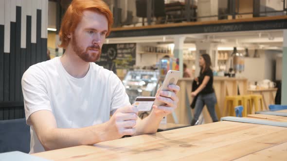 Redhead Man in Cafe Shopping Online on Smartphone, Payment alt