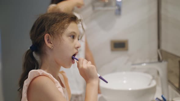 Two Cute Little Sisters Brush Their Teeth Together As They Get Ready for Bed