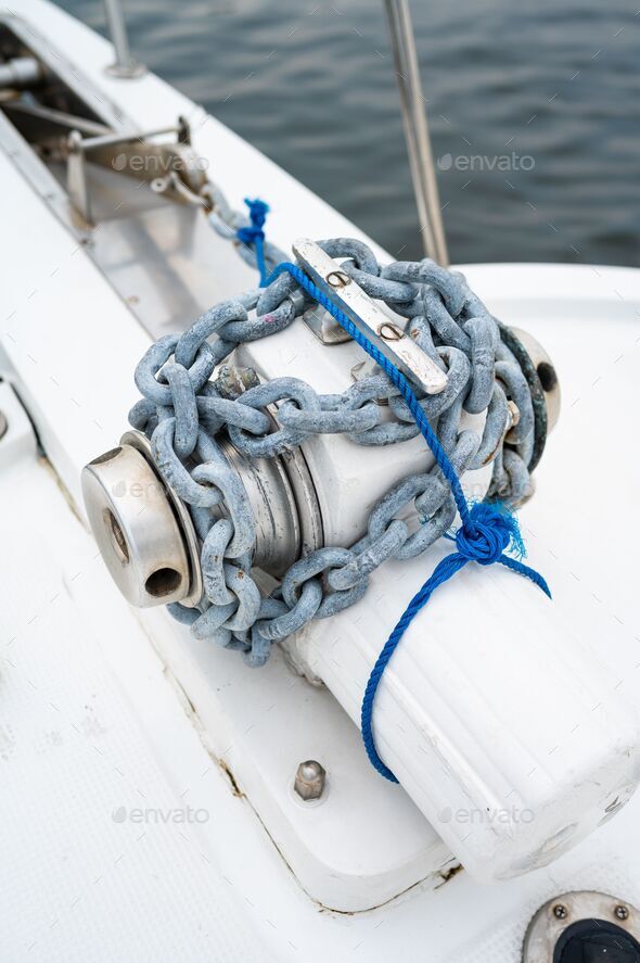 Anchor and the big chain holding it on the white yacht with the sea in the  blurred background Stock Photo by wirestock
