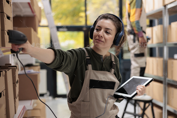 Supervisor wearing headset listening music during inventory - Stock Photo - Images