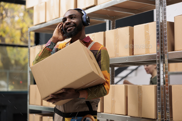 Warehouse supervisor carrying cardboard boxes - Stock Photo - Images