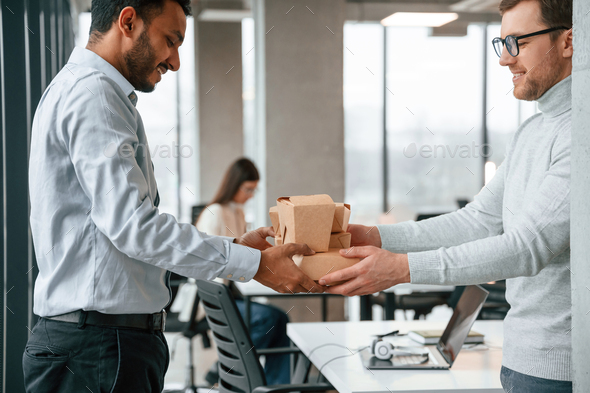 Taking the paper eco boxes. Men and woman are working in the office together - Stock Photo - Images
