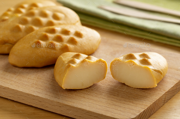 Traditional polish smoked cheese, mini “Gołka” Zakopianska, on a cutting board - Stock Photo - Images