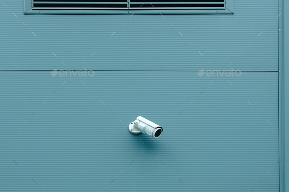 Outdoor surveillance security camera mounted on industrial building wall - Stock Photo - Images