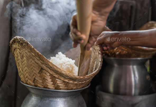 Hands cooking sticky rice with pot and rice steamer, traditional