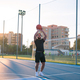 Afro-Latino man throws a ball to the basket on basketball court - PhotoDune Item for Sale