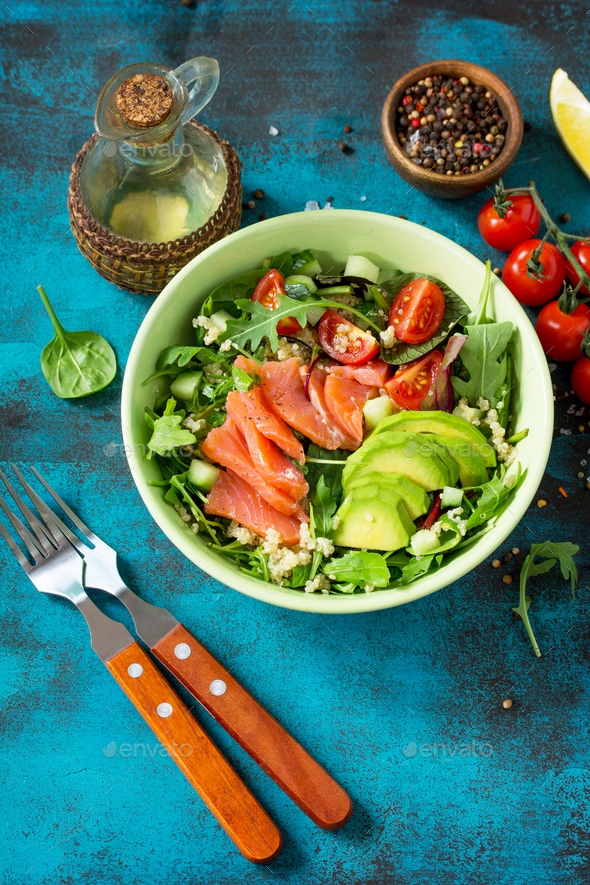 Diet menu, Vegan food. Healthy salad with quinoa, arugula, Tomatoes, Salmon and Avocado.