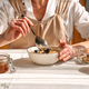 Female hands holding bowl of oatmeal porridge with blueberries, walnuts and honey. - PhotoDune Item for Sale
