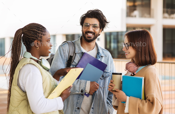 Happy young multiethnic people students in casual with headphones, notebooks study, communicate