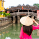 Young female tourist in Vietnamese traditional dress walking at Hoi An Ancient town in Vietnam - PhotoDune Item for Sale
