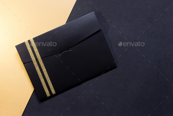 black envelope mockup, Flat Lay, on black and gold background with copy space.