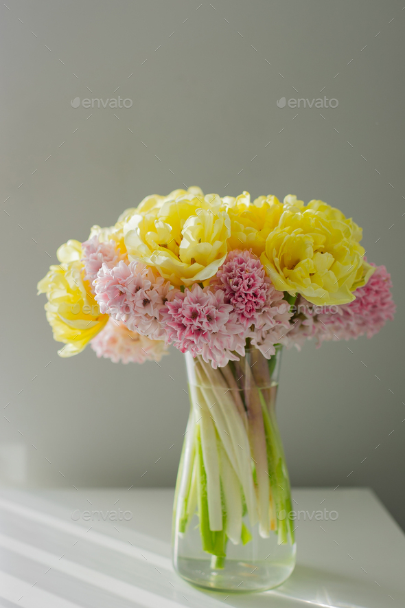 Beautiful yellow peony tulips and pink hyacinth flower bouquet on white dresser. - Stock Photo - Images