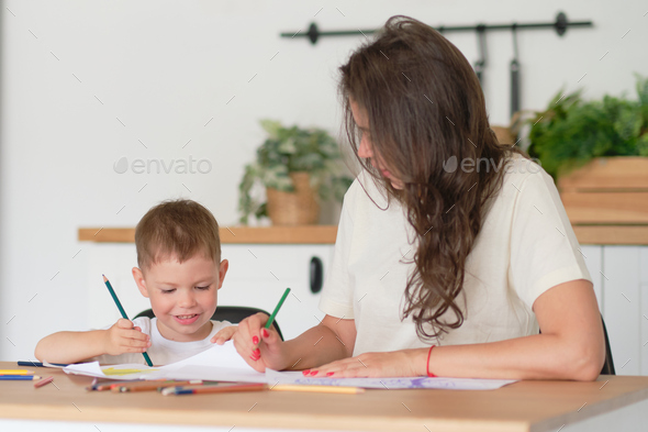 little boy learns to draw. Mom and son have fun drawing with pencils. Children's creativity.