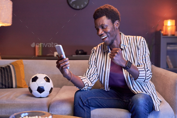 Excited black man using online betting app
