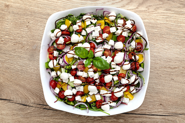 Vegetable salad on a white plate consisting of vegetables, cheese and balsamic dressing. - Stock Photo - Images