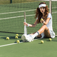 beautiful female tennis player with racket sitting near tennis net on court with tennis balls around - PhotoDune Item for Sale