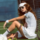 side view of fashionable female tennis player in sunglasses resting near net on tennis court with - PhotoDune Item for Sale