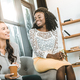 multiethnic smiling businesswomen drinking coffee together during break in office - PhotoDune Item for Sale