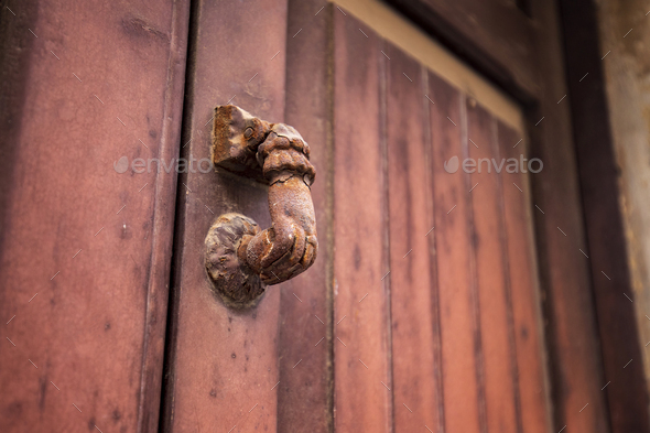 Door knocker. Old antique metal knocker on the wooden doors for knocking. Close up
