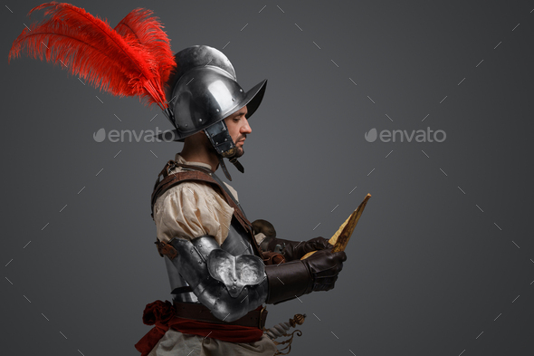 Conquistador dressed in armor and helmet exploring map - Stock Photo - Images