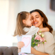 Daughter giving mother bouquet of flowers. - PhotoDune Item for Sale