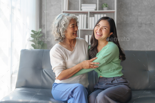 60s asian mother elderly sitting on sofa with young asia female ...