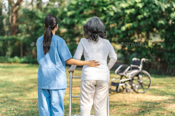 Young asian care helper with asia elderly woman on wheelchair relax together park outdoors to help